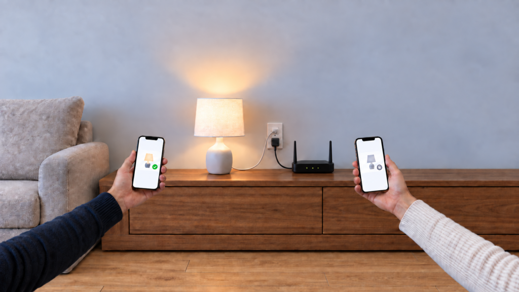 Two phones on the same home Wi-Fi show a lamp available on one phone and locked on the other beside a powered router with its ports facing the wall.